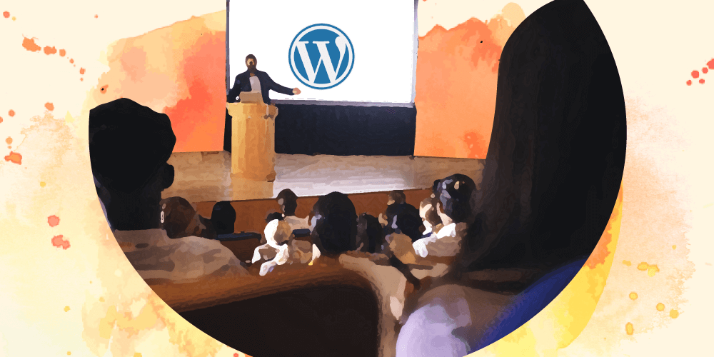 A person speaking in front of a crowd with a WordPress logo behind them on the screen
