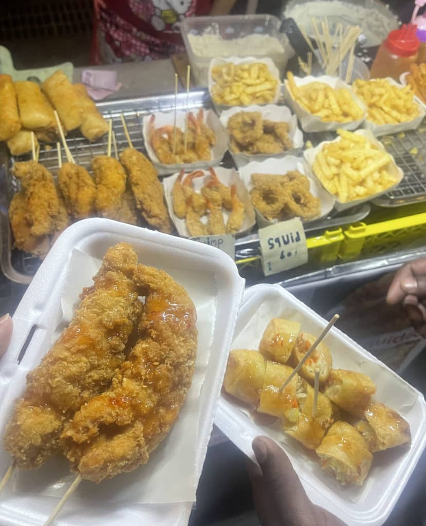 Street food consisting of fried chicken, spring rolls, shrimp and fries